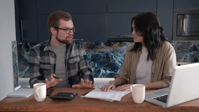 a man and a woman sitting at a table with a laptop