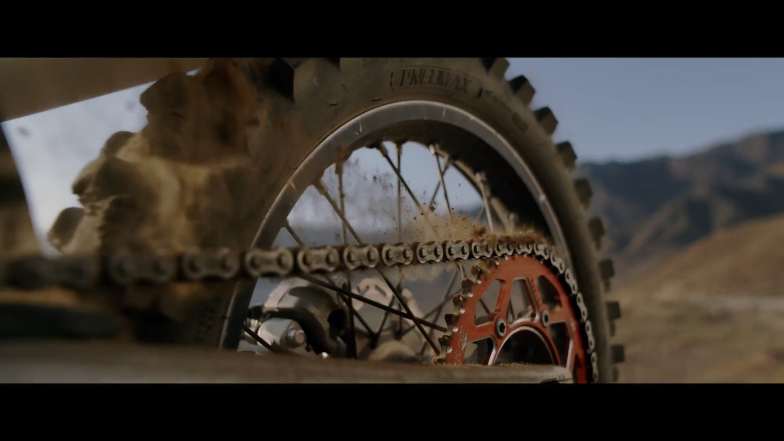 a close up of a bike tire with mountains in the background