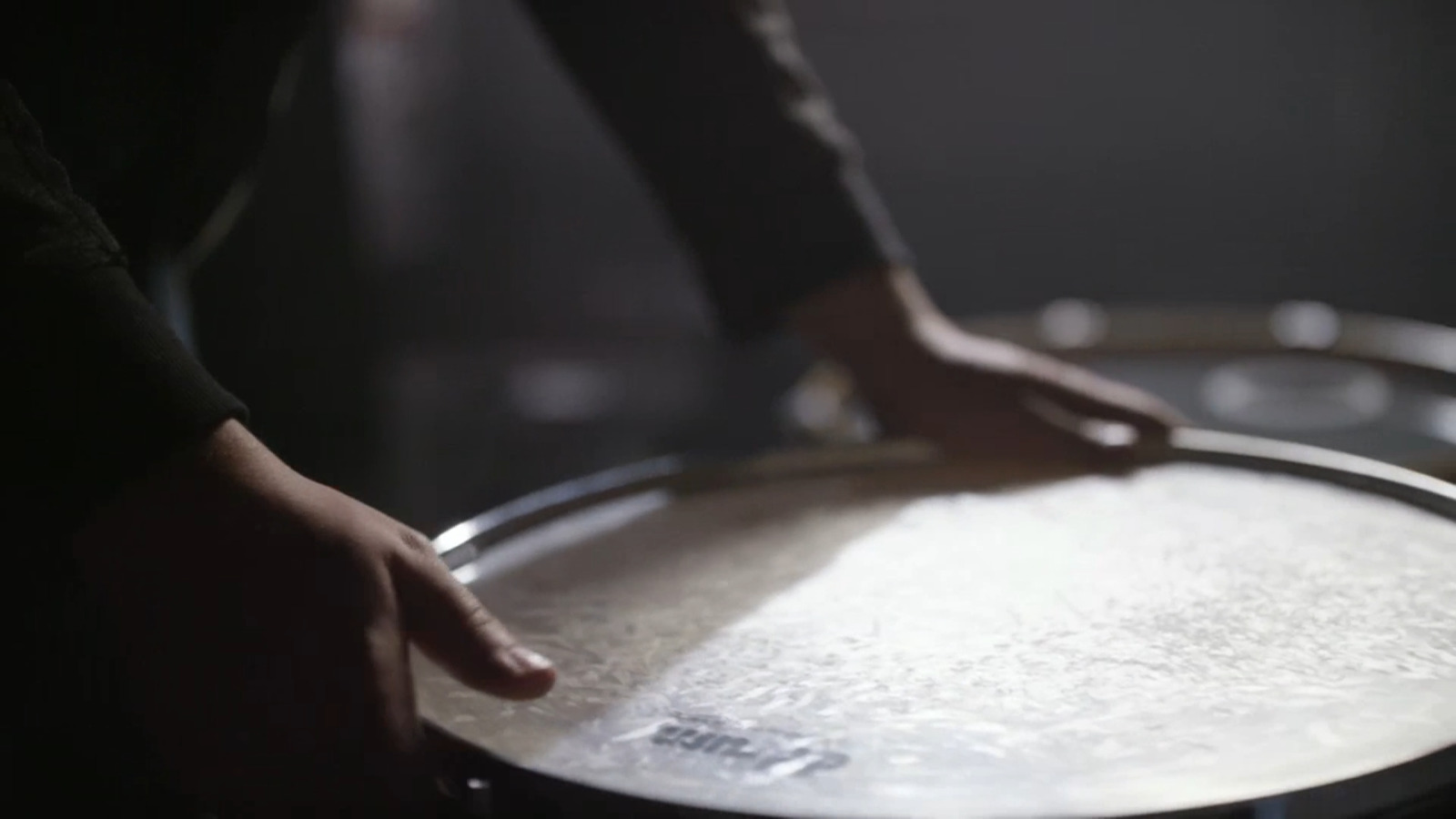 a person is touching a drum with their hand