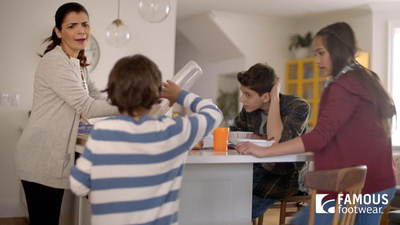 a group of people standing around a kitchen table