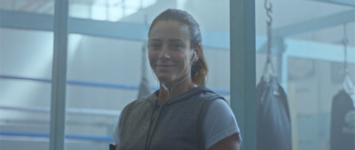 a woman is listening to music in a gym