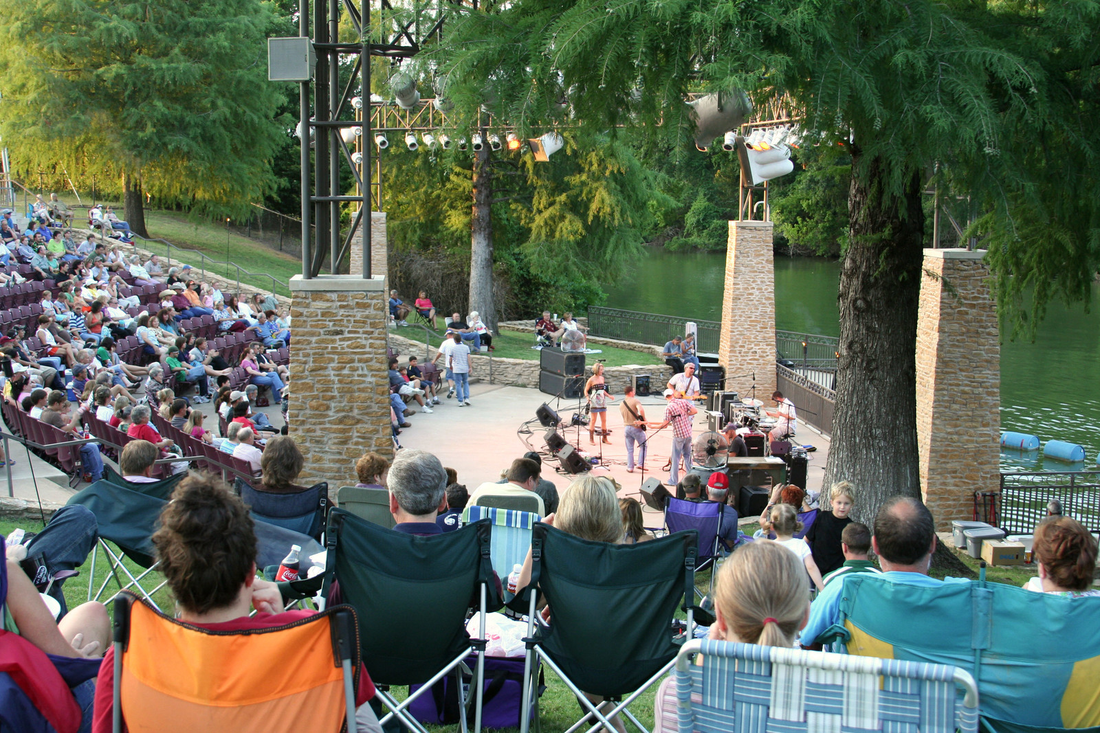 a group of people sitting in lawn chairs in front of a stage