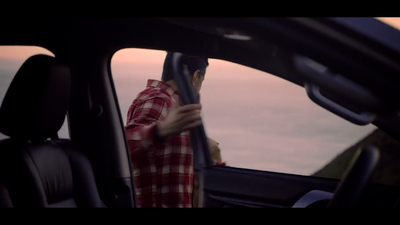 a man sitting in a car looking at his cell phone