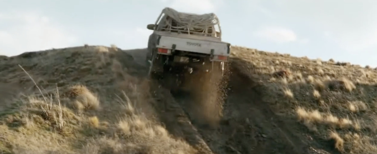 a white truck driving down a dirt road