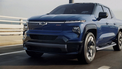 a blue chevrolet truck driving down a highway