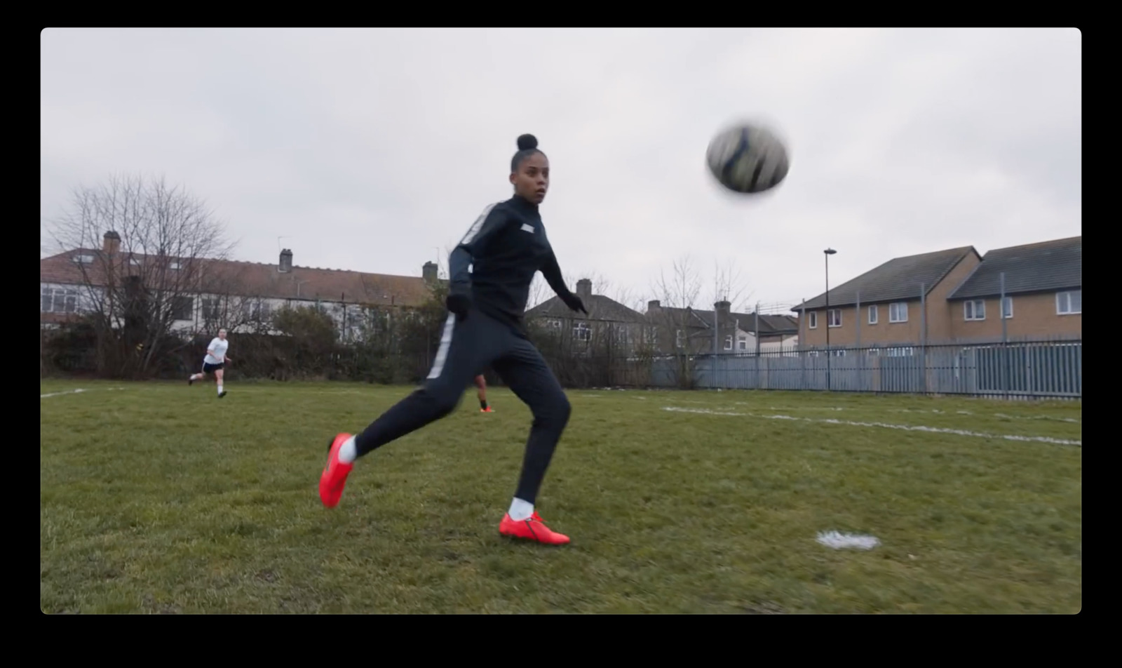 a woman kicking a soccer ball on top of a field