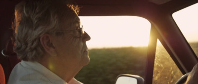 a man driving a car with the sun behind him