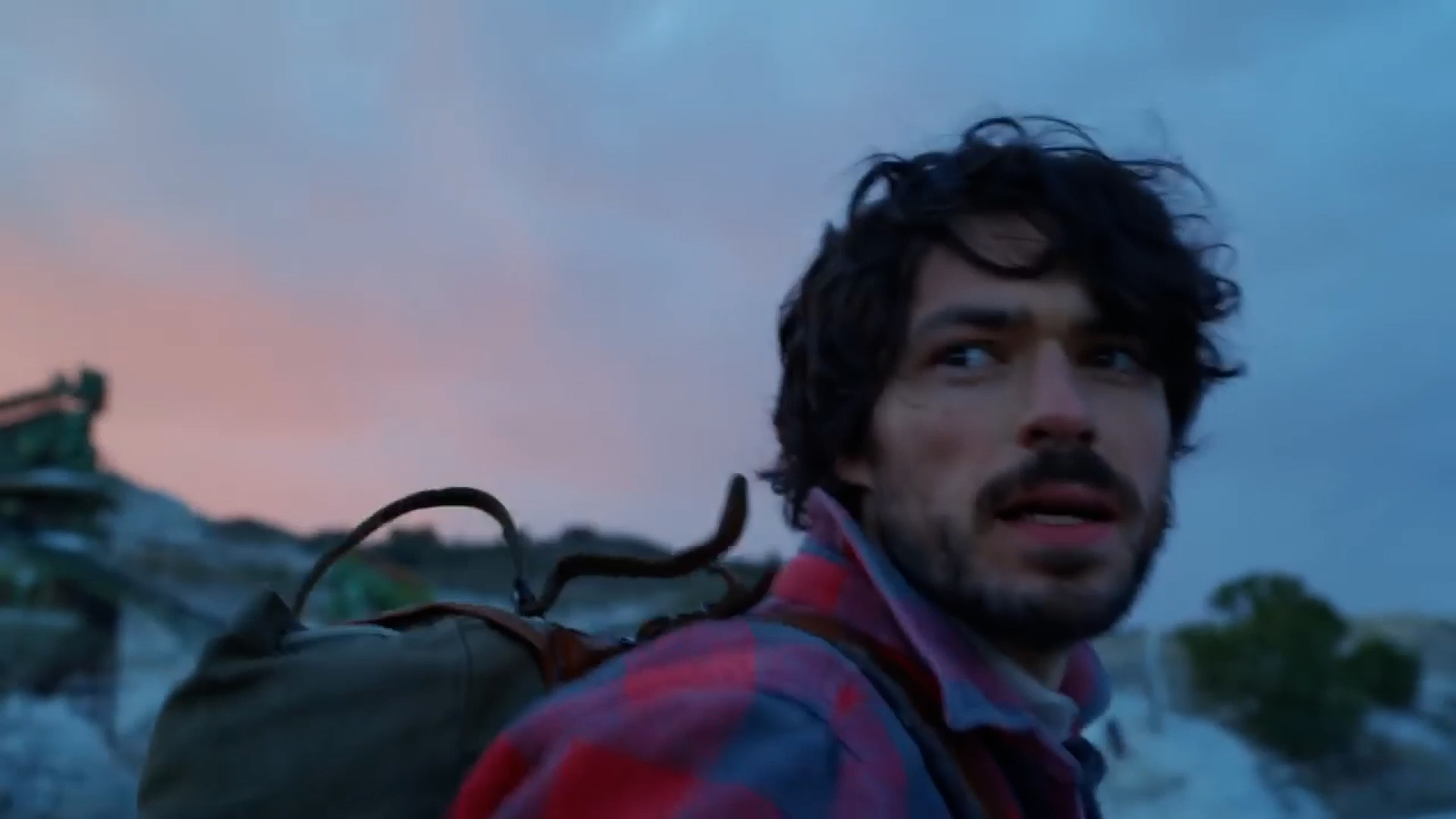 a man with a backpack looking up at the sky