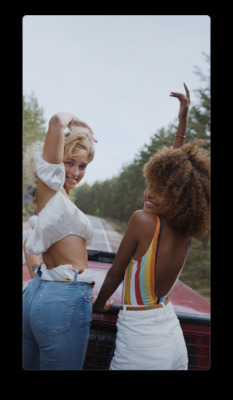 two women standing next to each other near a car