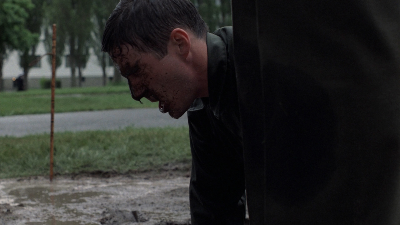 a man with his mouth open standing in the rain