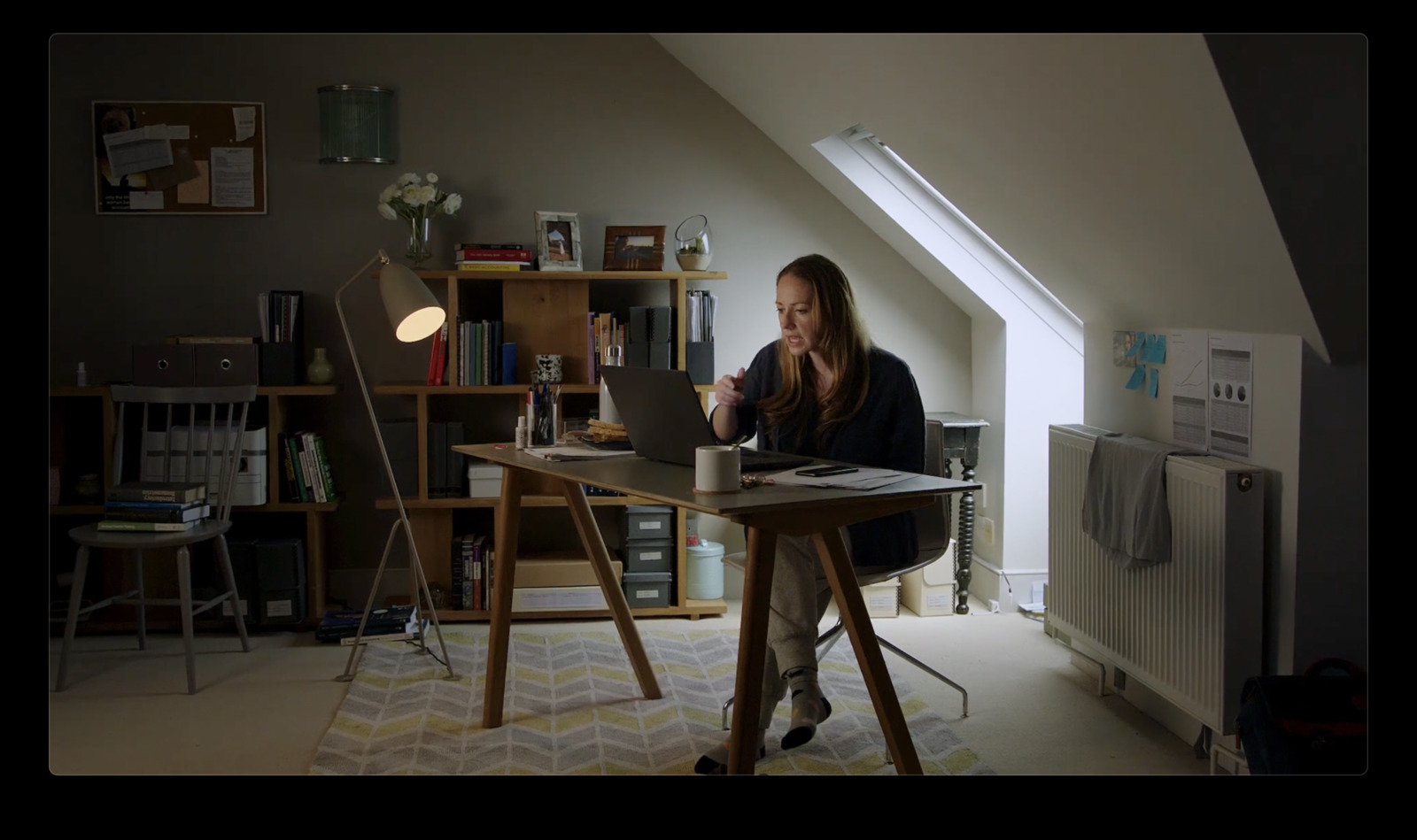 a woman sitting at a desk with a laptop computer