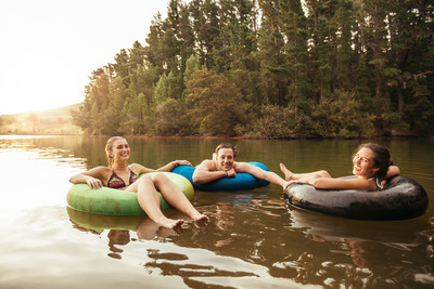 three people floating on inflatables in a lake