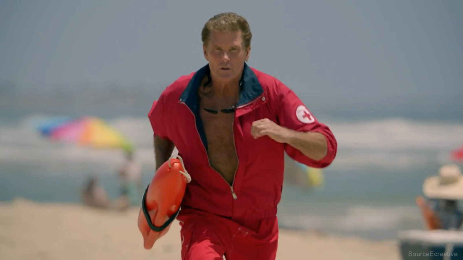 a man running on the beach with a life preserver