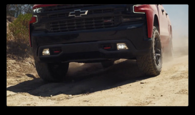 a red truck driving down a dirt road