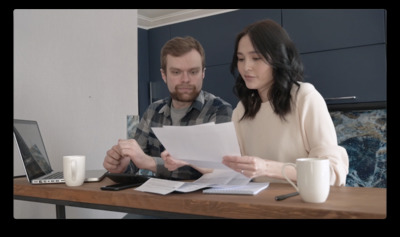 a man and woman sitting at a desk looking at papers