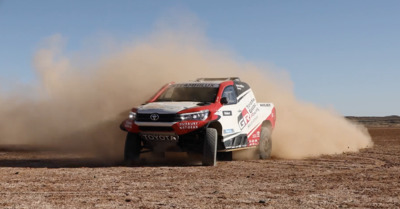 a red and white truck driving down a dirt road