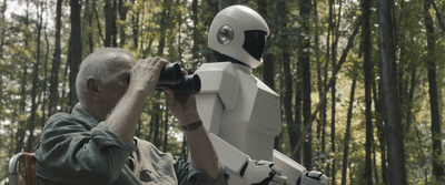 a man looking through a pair of binoculars at a robot