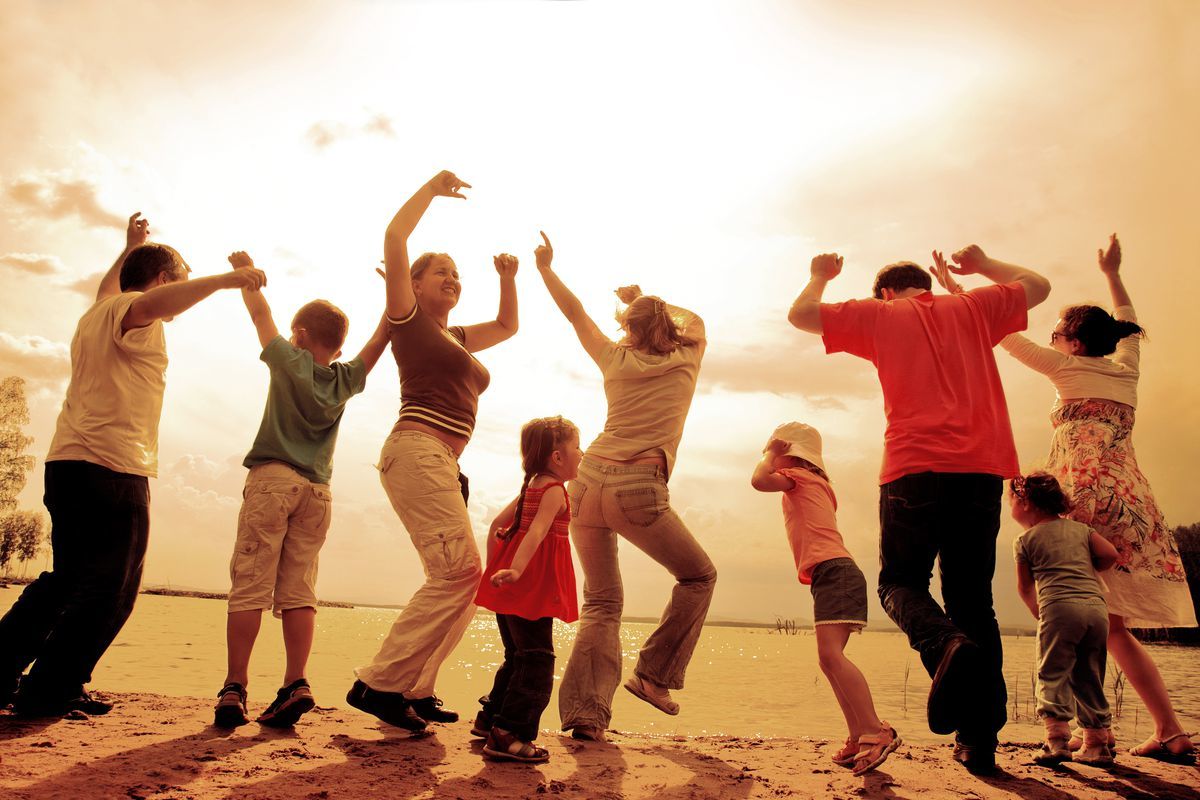 a group of people standing on top of a sandy beach