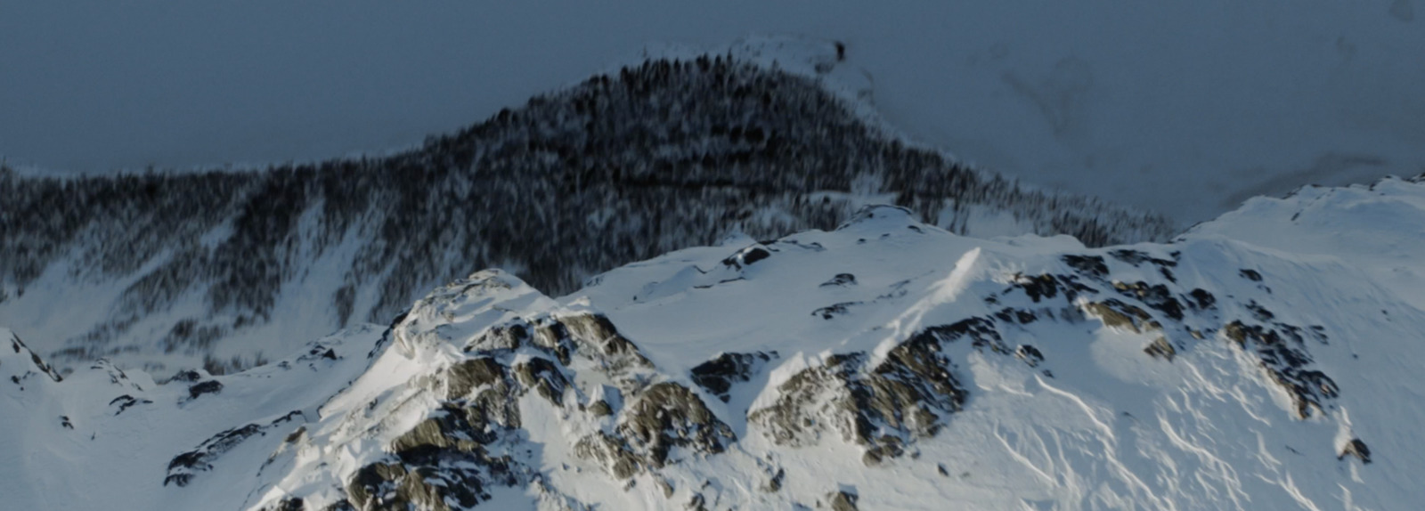 a mountain covered in snow with a sky background