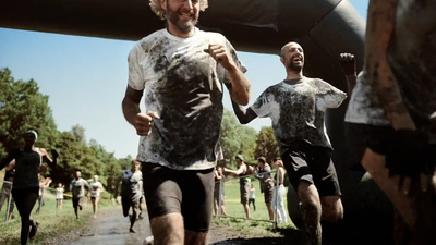 a group of men running down a dirt road