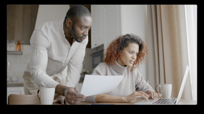 a man and a woman looking at a laptop