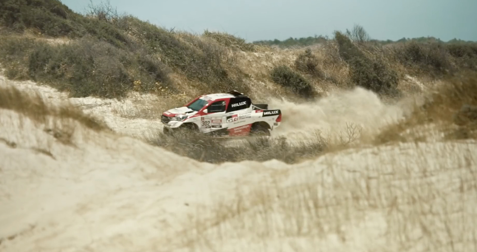 a truck is driving through the sand dunes