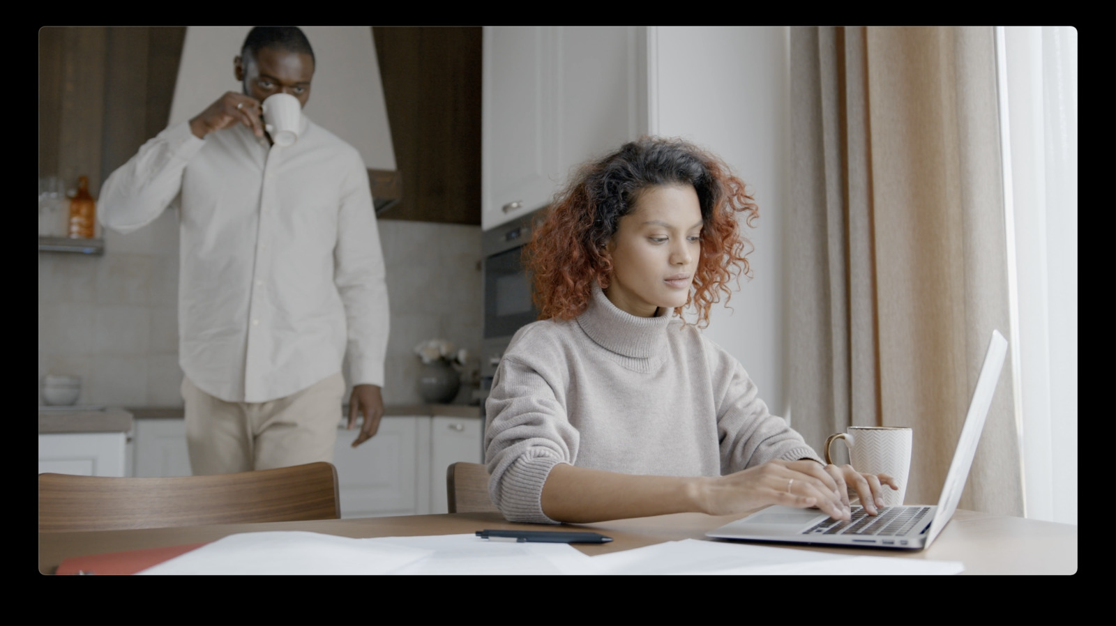 a woman sitting at a table using a laptop computer