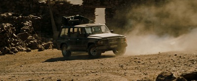 a jeep driving down a dirt road in the desert