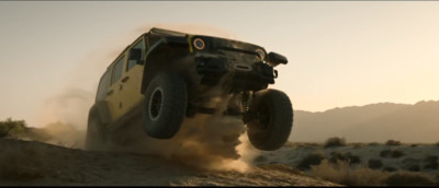 a jeep driving down a dirt road in the desert