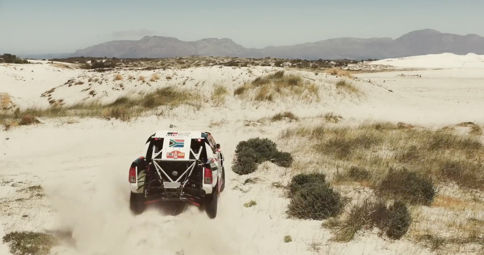 a buggy driving through the desert on a sunny day