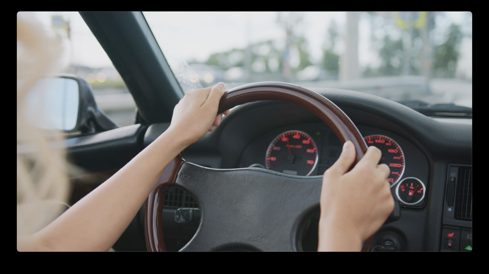 a woman driving a car with a steering wheel