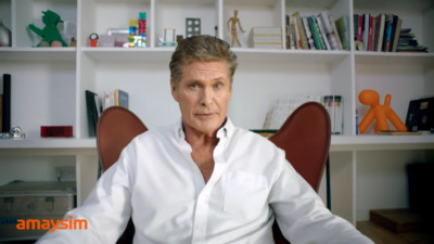 a man sitting in a chair in front of a book shelf