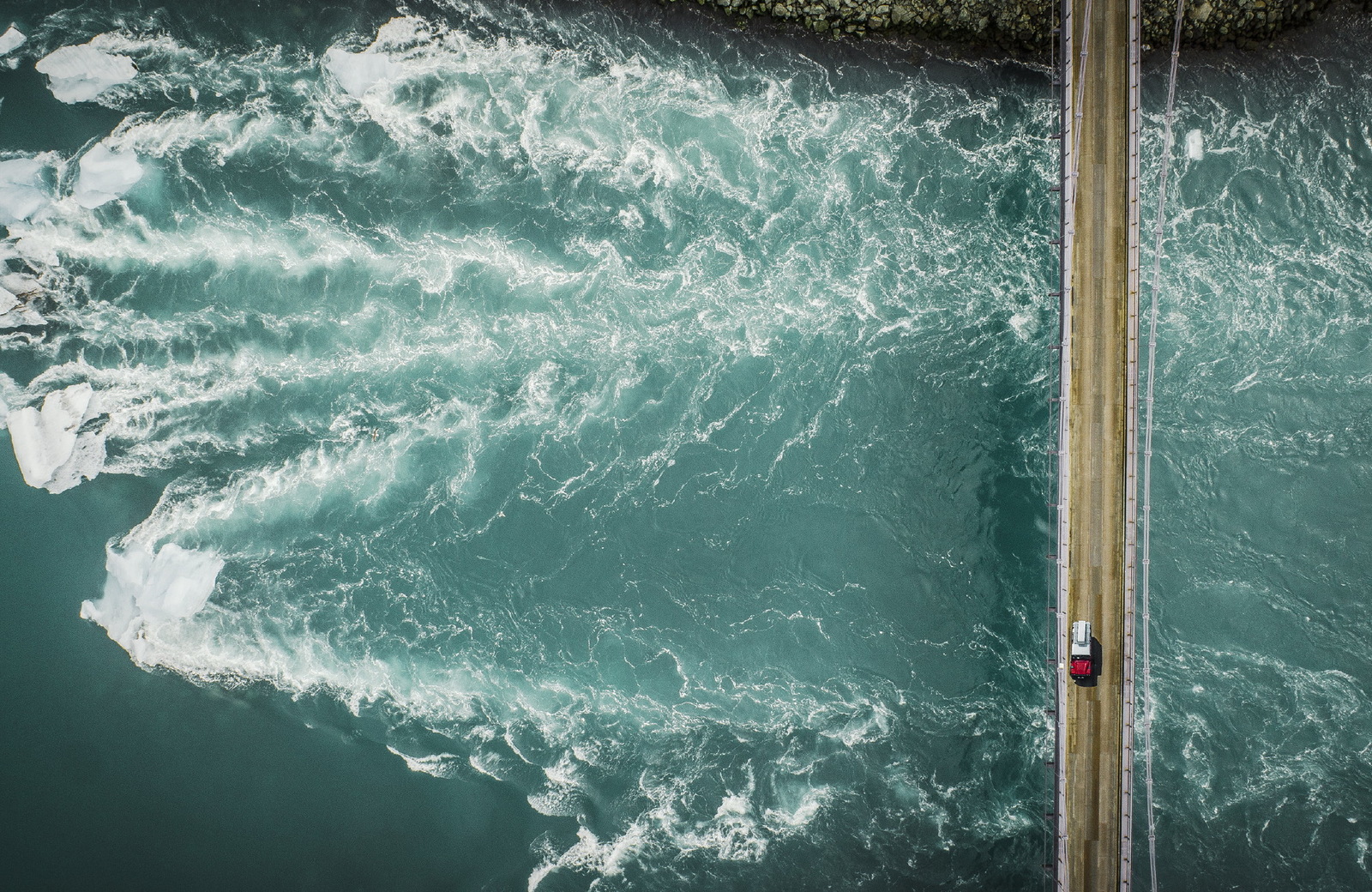 an aerial view of the ocean with a boat in the water