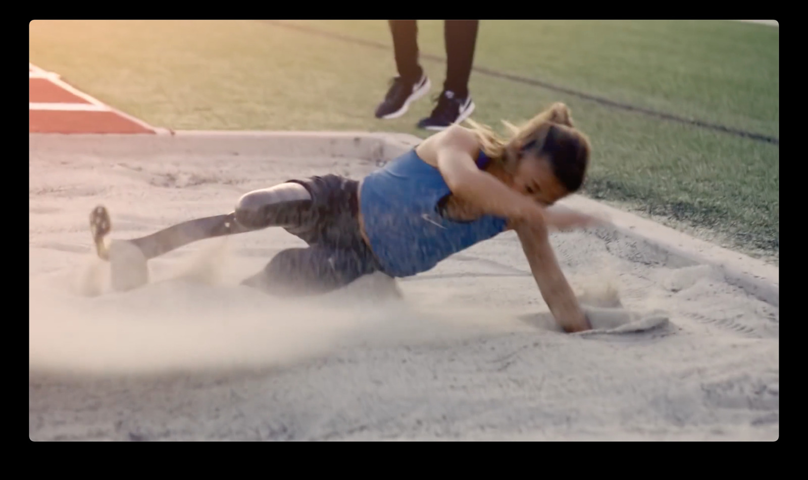 a woman in a blue shirt is on a baseball field