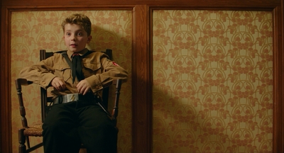 a young man sitting in a chair in a room