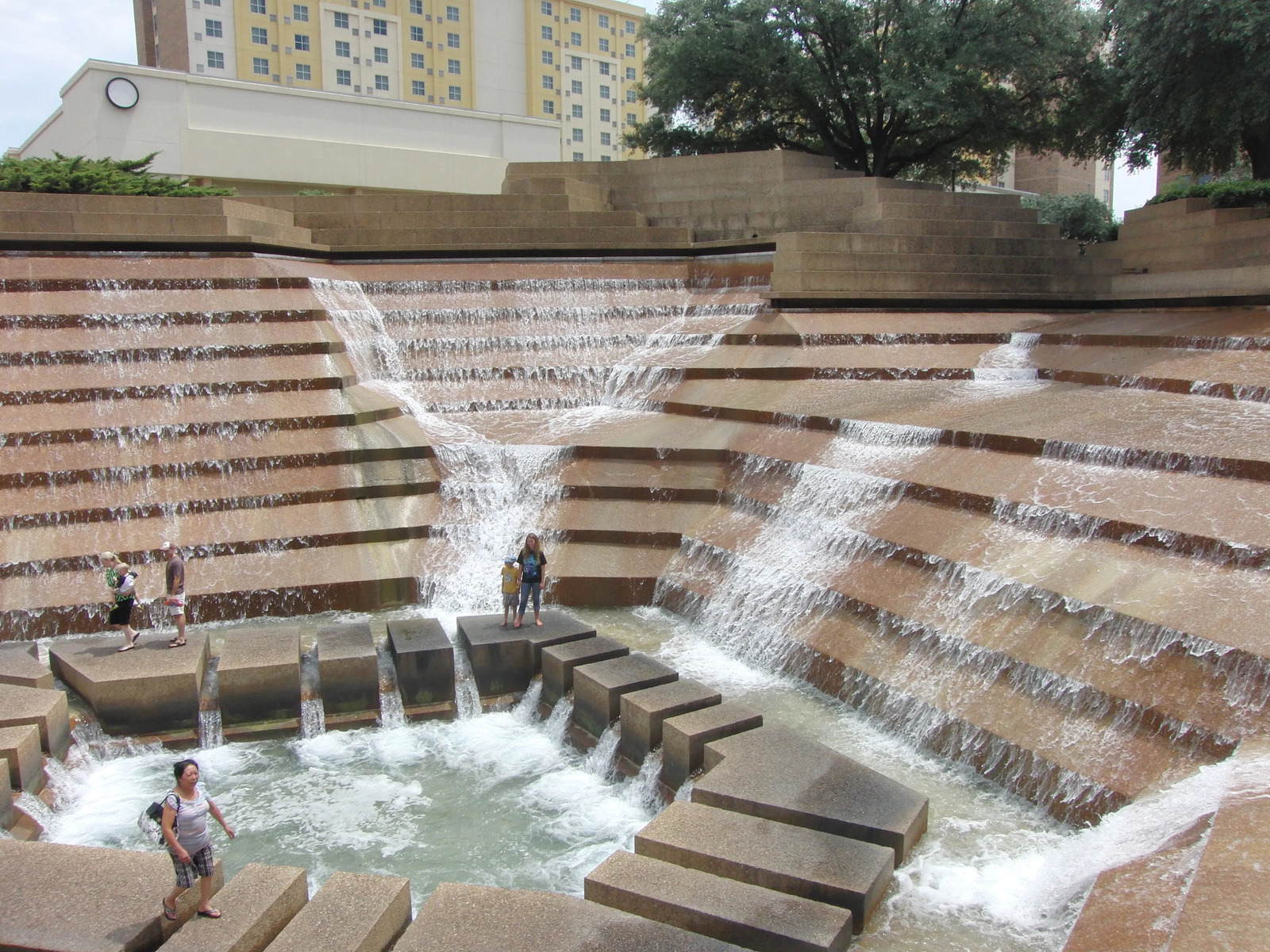 a group of people standing next to a waterfall