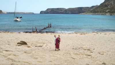 a woman standing on top of a sandy beach