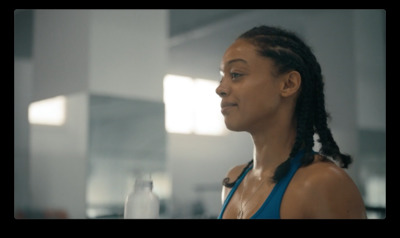 a woman in a blue tank top holding a glass of water