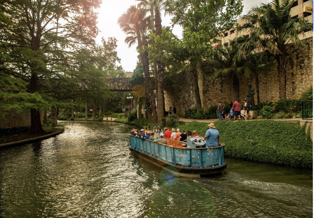 a boat filled with people riding down a river