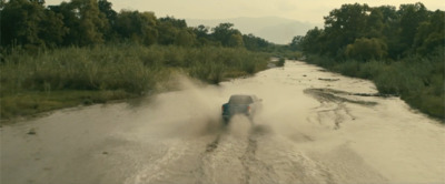 a truck is driving through a muddy river