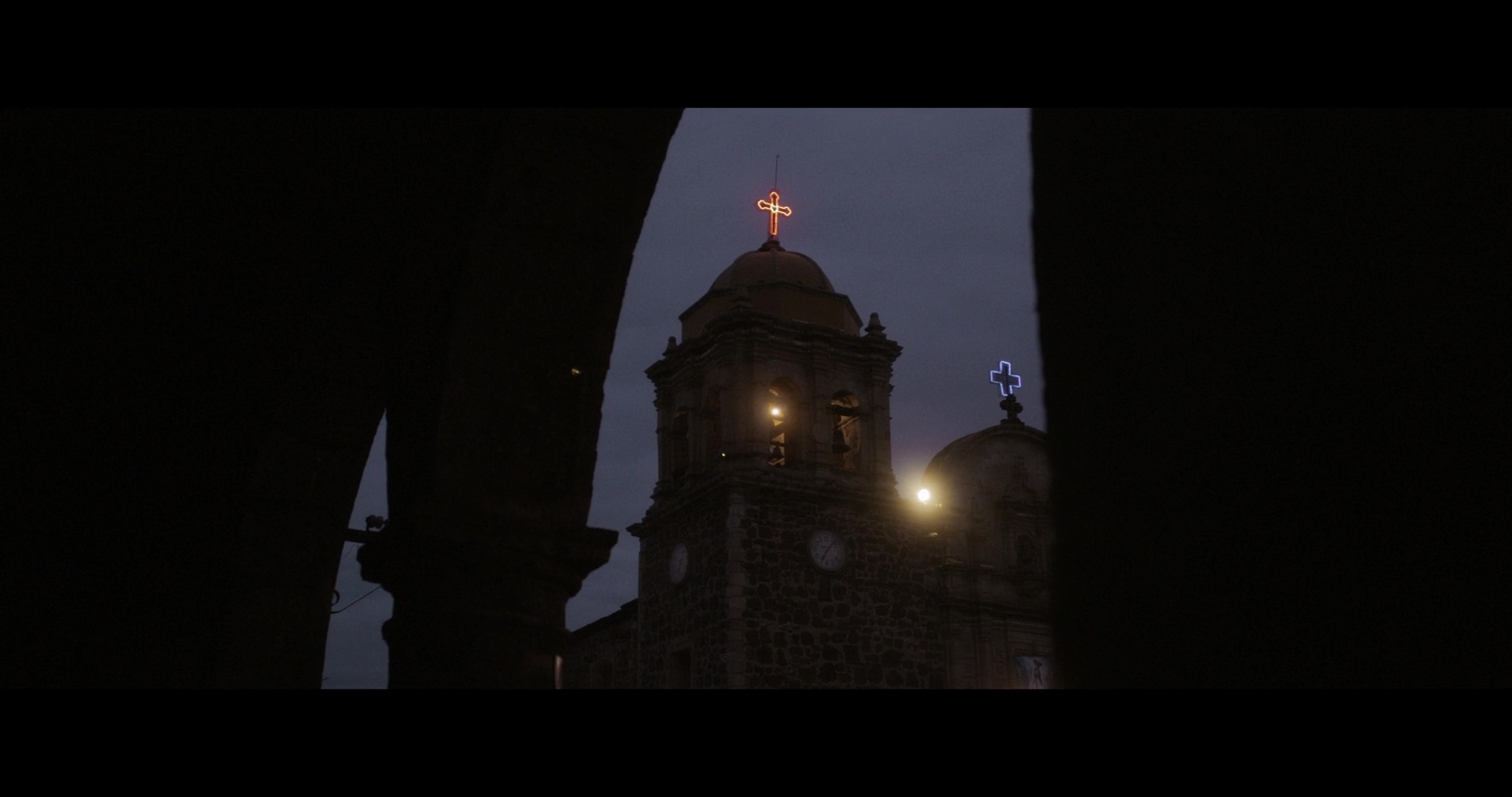 a tall building with a clock tower lit up at night