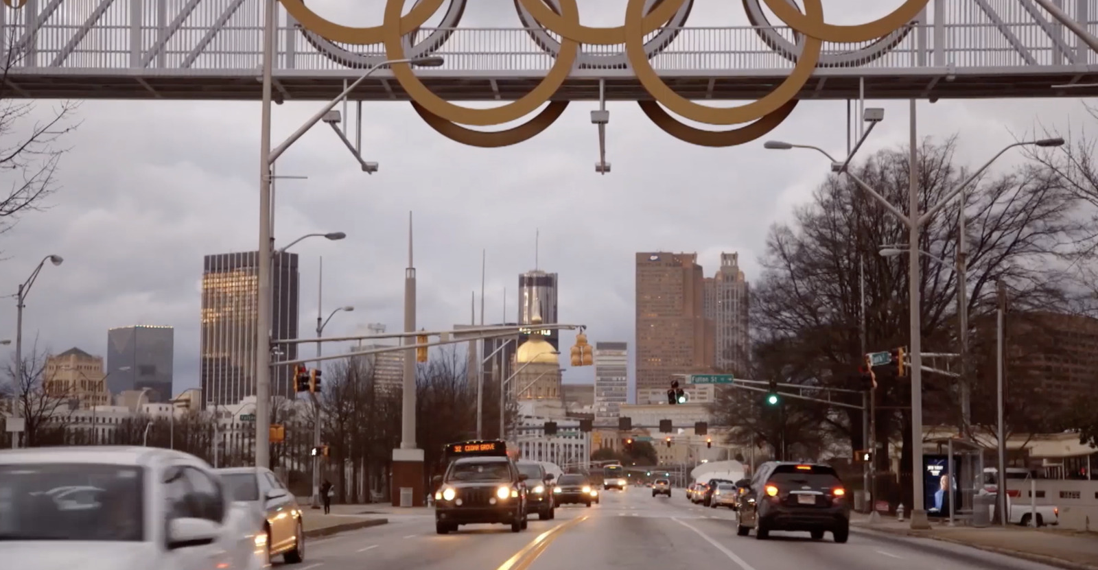 a city street filled with lots of traffic under a bridge