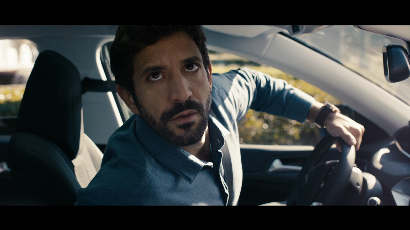 a man driving a car with a surprised look on his face