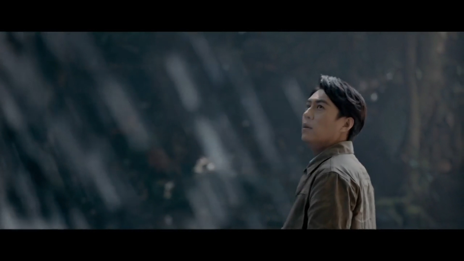 a man standing in front of a waterfall