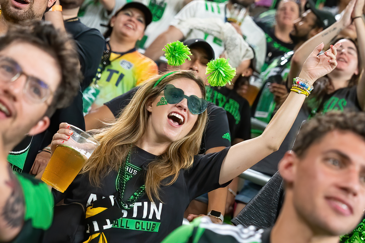 a group of people in a stadium with their arms in the air