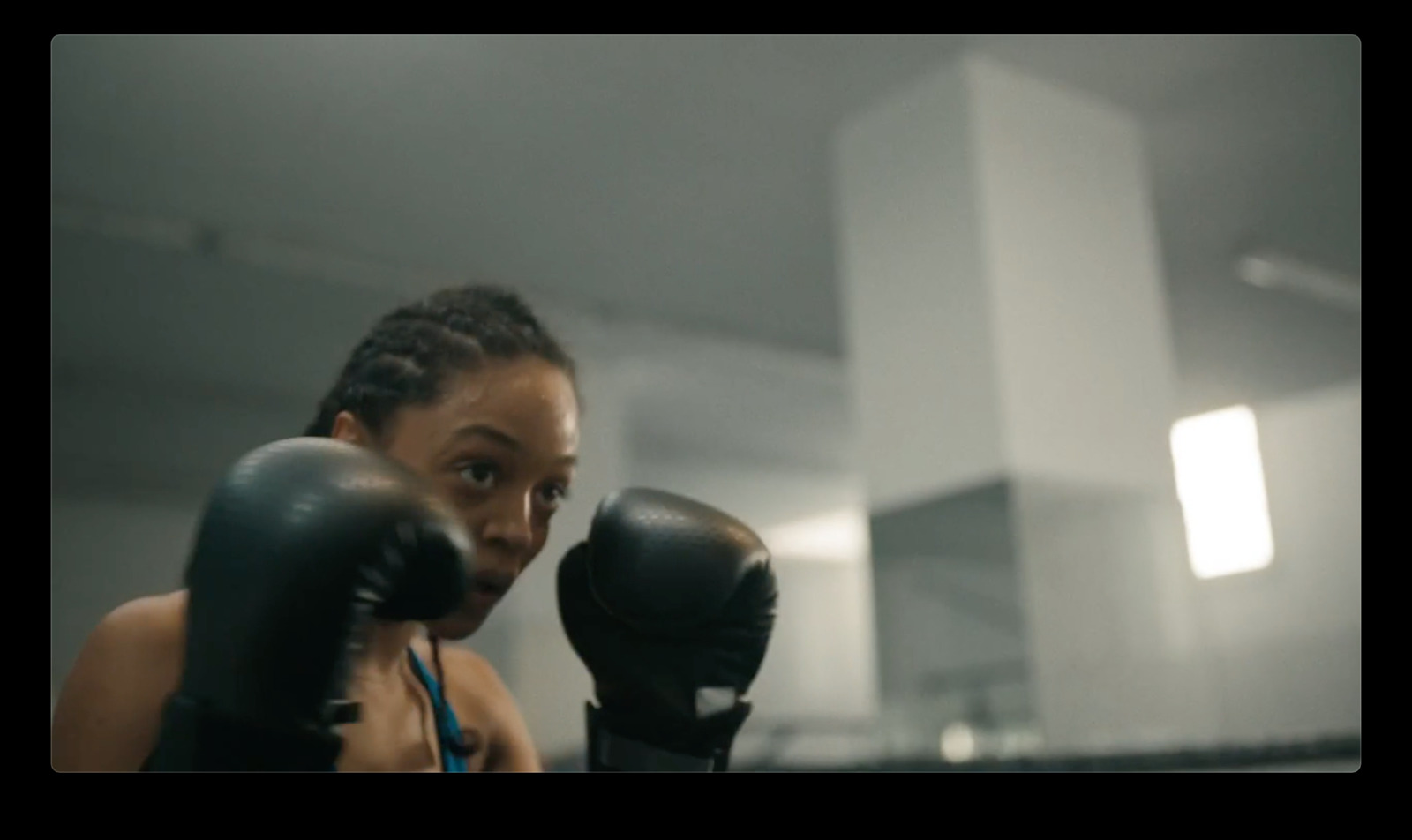 a woman wearing boxing gloves in a gym