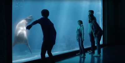 a group of people standing in front of a large aquarium