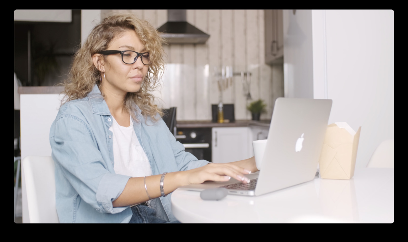 a woman sitting at a table using a laptop computer