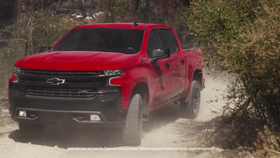 a red truck driving down a dirt road