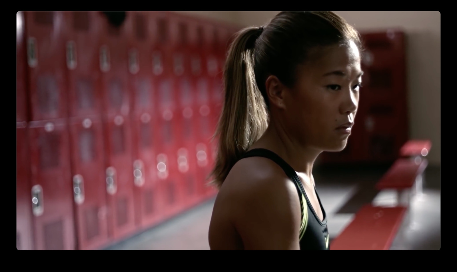 a woman standing in front of lockers in a gym